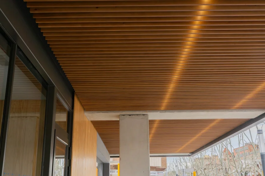 Paneles acústicos decorativos Woodslines: revestimiento de madera en el techo de un paso cubierto del Campus Universitario de Igualada.